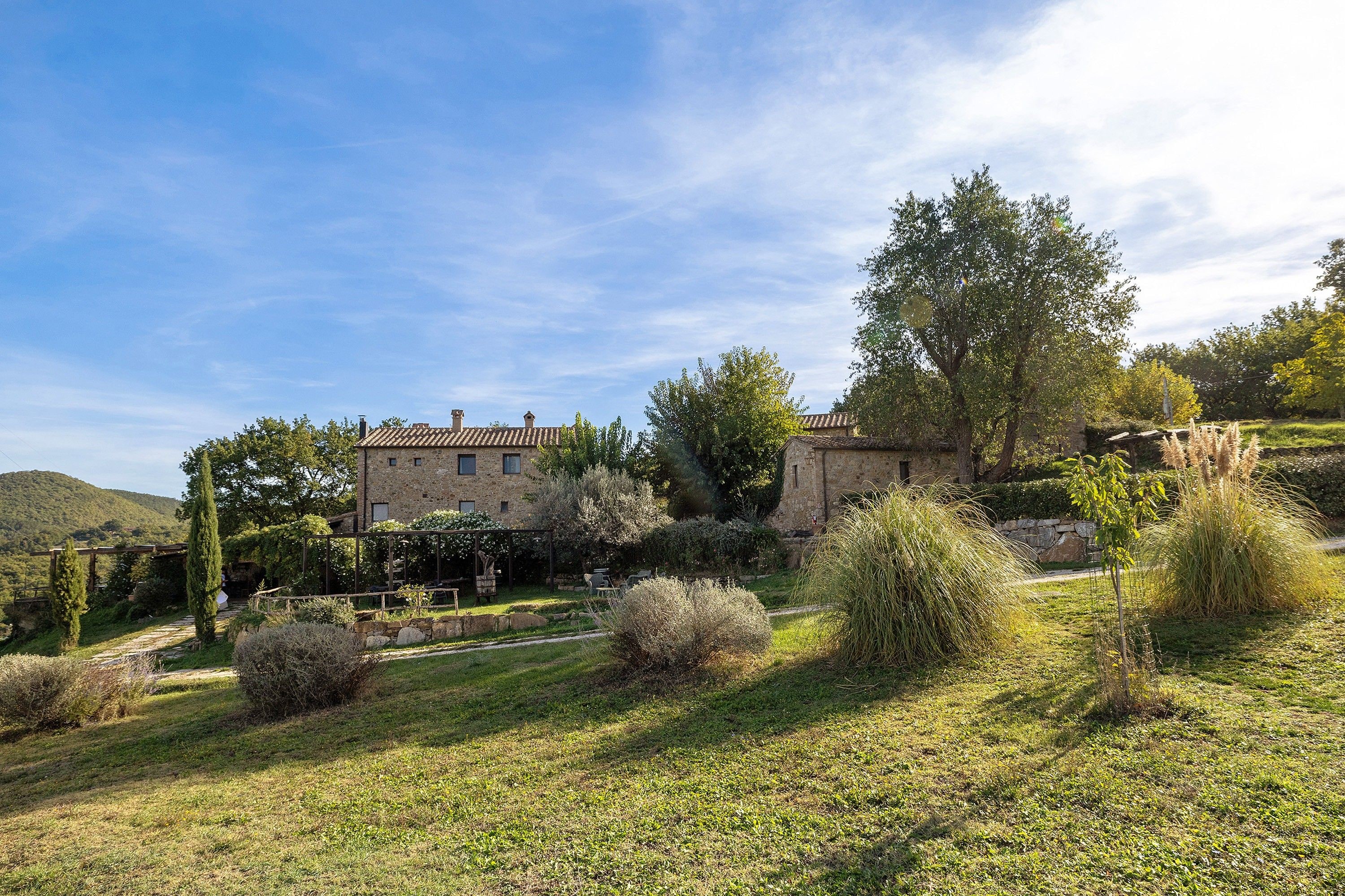 Un edificio de piedra con jardín y vistas al campo.