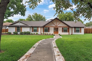 A single-story house with a front entrance, a covered porch, and a well-maintained lawn. - Your Home Away From Home - Furnished Arlington Retreat - Nearly 1 Acre lot (Arlington)