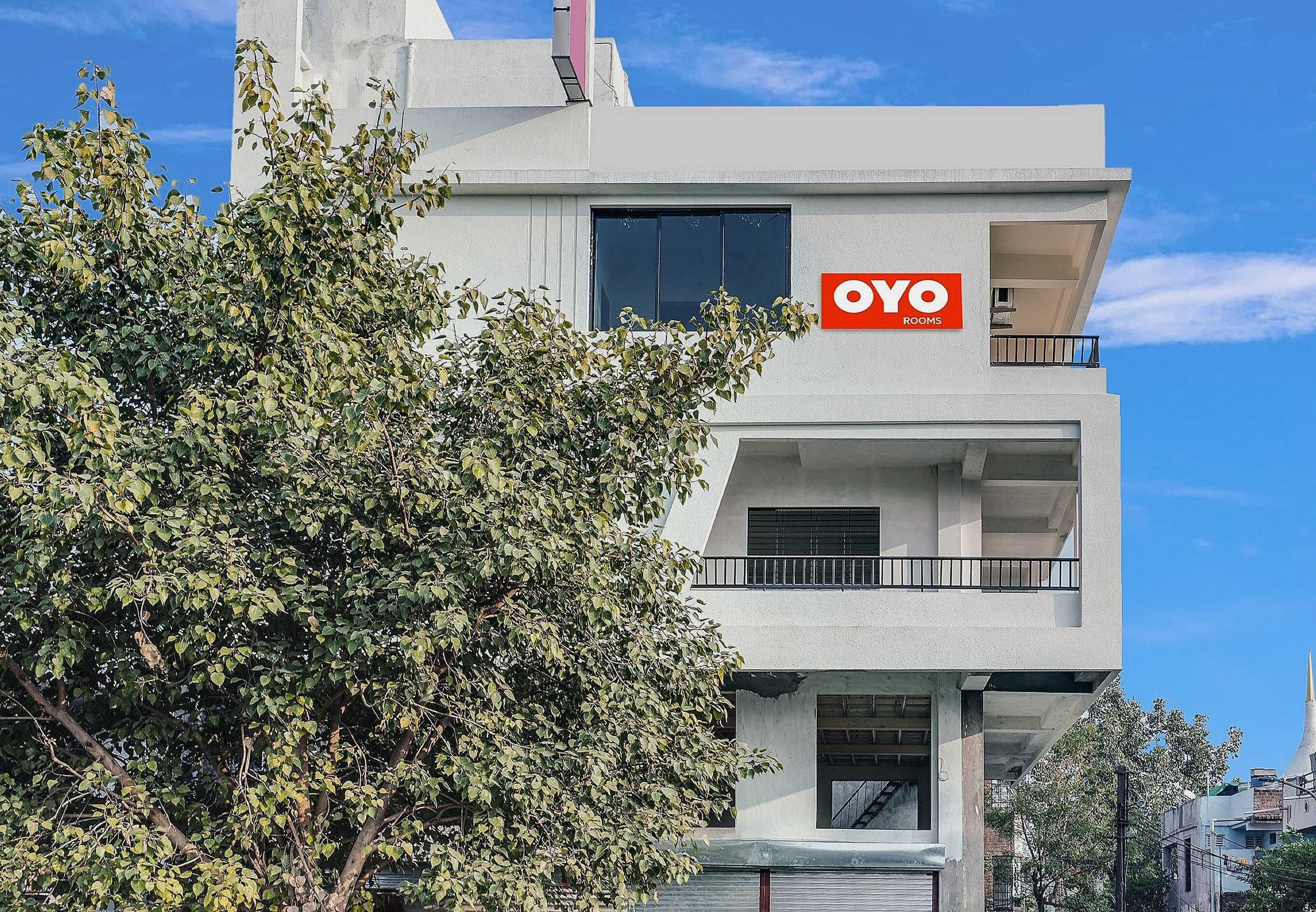 A modern building with a sign for 'OYO ROOMS' indicating a hotel or accommodation.