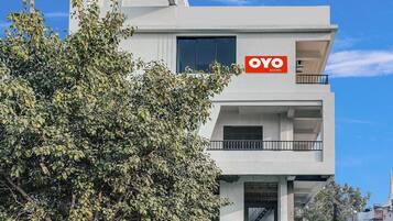 A modern building with a sign for 'OYO ROOMS' indicating a hotel or accommodation.