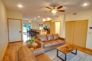 A living room with a sofa, a coffee table, and a dining area with chairs.