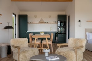 A compact living space with a dining area, kitchenette, and seating arrangement. - Luxury Retreat in Angus with Sunset Valley Views (Angus)