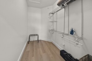 A room with white walls, a wooden floor, and metal shelving units. - Completely Renovated Beach Home | Private Pool + Golf Cart | Near 30A (Panama City Beach)