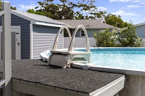 A swimming pool with a built-in diving board and a ladder. - Completely Renovated Beach Home | Private Pool + Golf Cart | Near 30A (Panama City Beach)