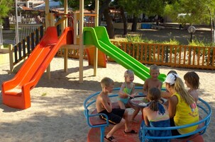 Un parque infantil con toboganes y una zona de estar circular.
