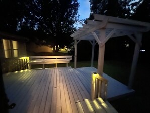 A wooden deck with a bench and a pergola structure. - 3-bedroom house in delightful Decatur with cool AC breeze (Decatur)