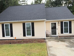 A two-story house with a dark roof, beige siding, and black shutters. - 3-bedroom house in delightful Decatur with cool AC breeze (Decatur)