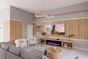 A modern living room with a large flat-screen TV, a fireplace, and a sofa. - 12BR house sleeps 24 with spa and pool table (Orlando)