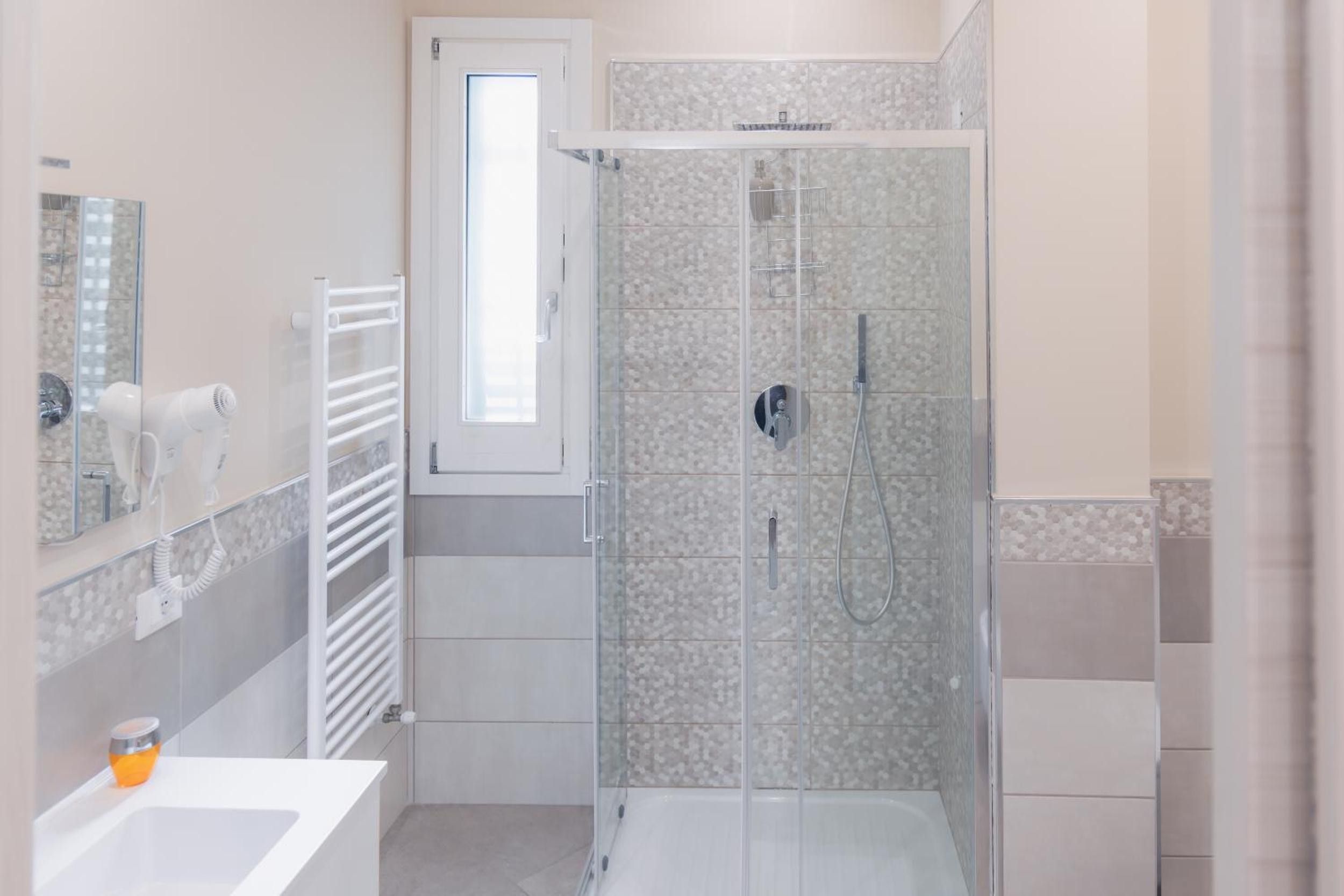 A modern bathroom with a shower, a toilet, and a sink.