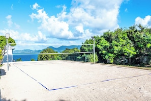 An outdoor volleyball court with a net, surrounded by trees and a view of the sea. - Villa & dômes : 8 bdr - Breathtaking 180° views - Beach Access & Pickle ball (Les Terres Basses)