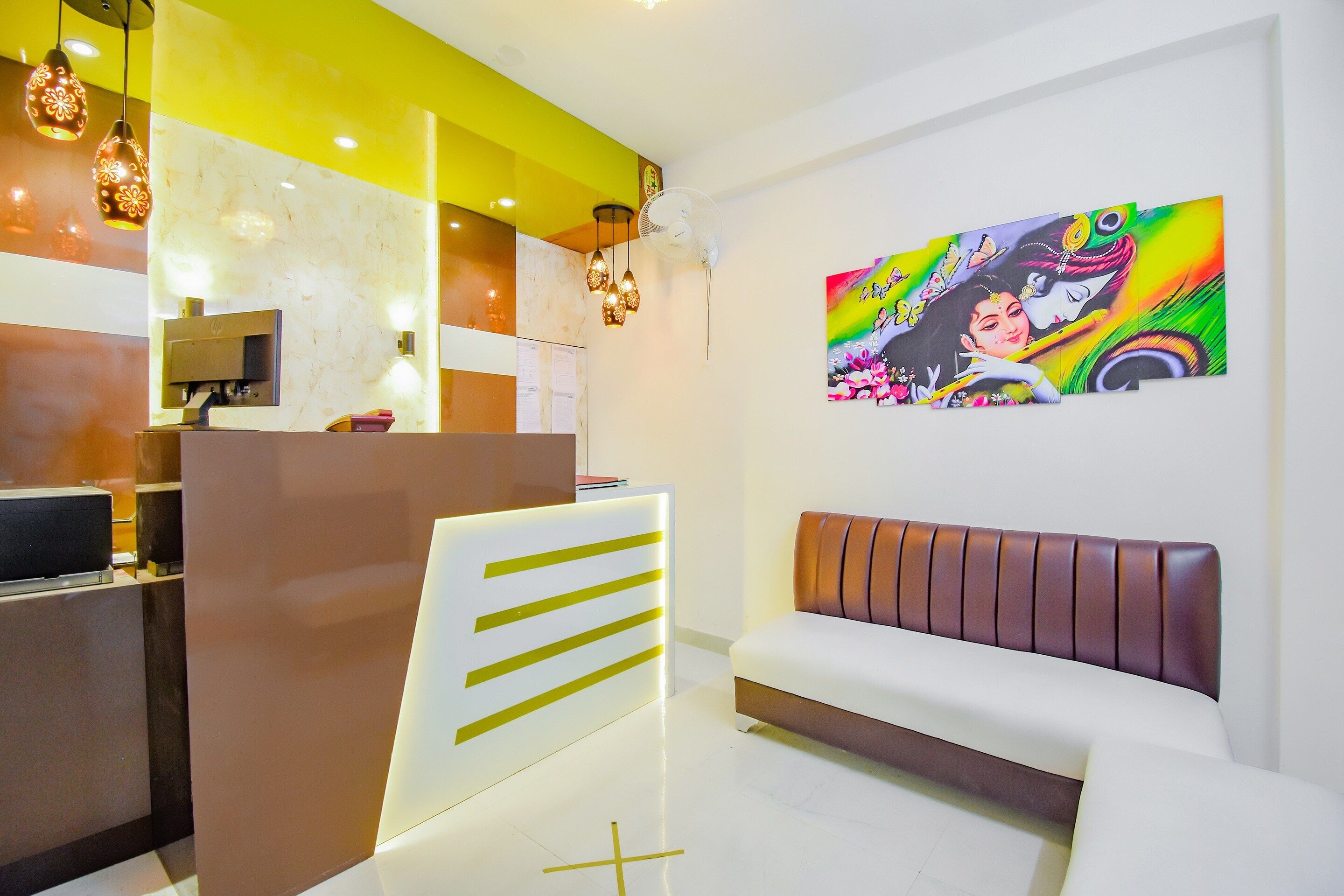 Een receptiezone in modern design, met een receptiebalie, een zithoek en kunst aan de muur.