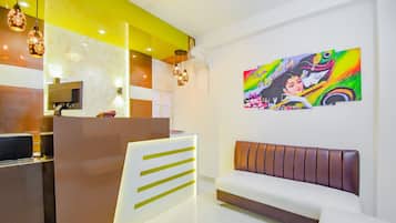 Een receptiezone in modern design, met een receptiebalie, een zithoek en kunst aan de muur.