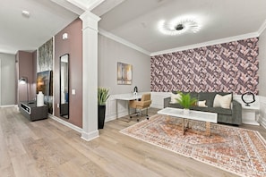 Ein modernes Wohnzimmer mit einem grauen Sofa, einem weißen Couchtisch und einem gemusterten Teppich.