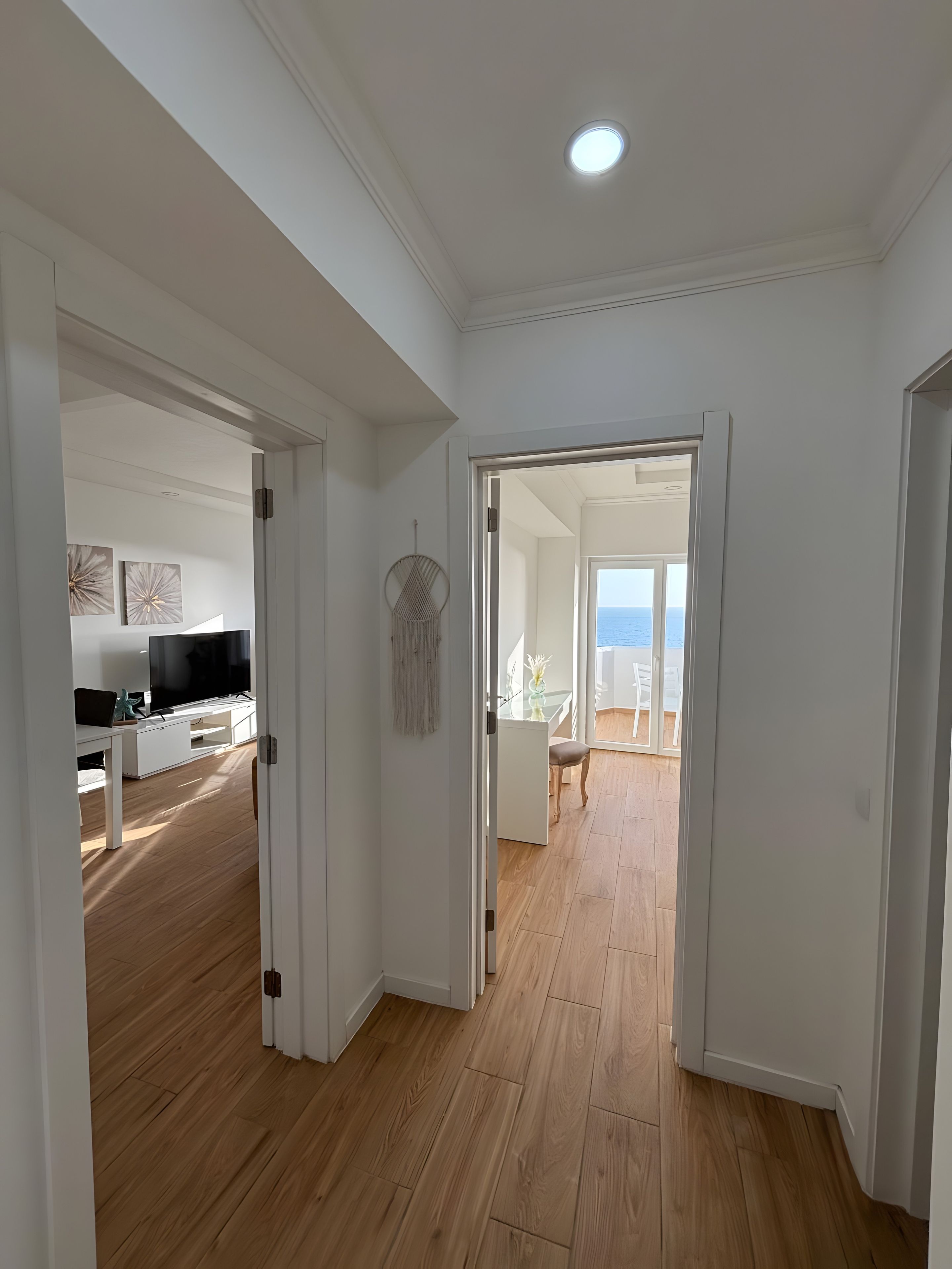 A hallway leading to a dining area with a view of the sea.