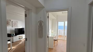 A hallway leading to a dining area with a view of the sea.