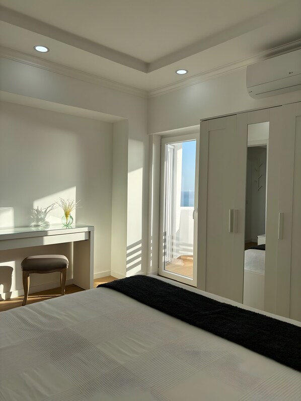 A bedroom with a bed, a desk, and a wardrobe. - Holiday Home 'Modern and Sunny, Sea View' with Wi-Fi and Air Conditioning (Quarteira)