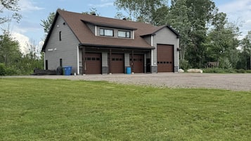 A two-story house with a garage, a covered porch, and a large lawn.