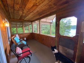 A wooden cabin with a porch, a dog, and a view of a lake. - Cozy lakefront chalet, breathtaking views, high-speed wifi (Sainte-Thérèse-de-la-Gatineau)