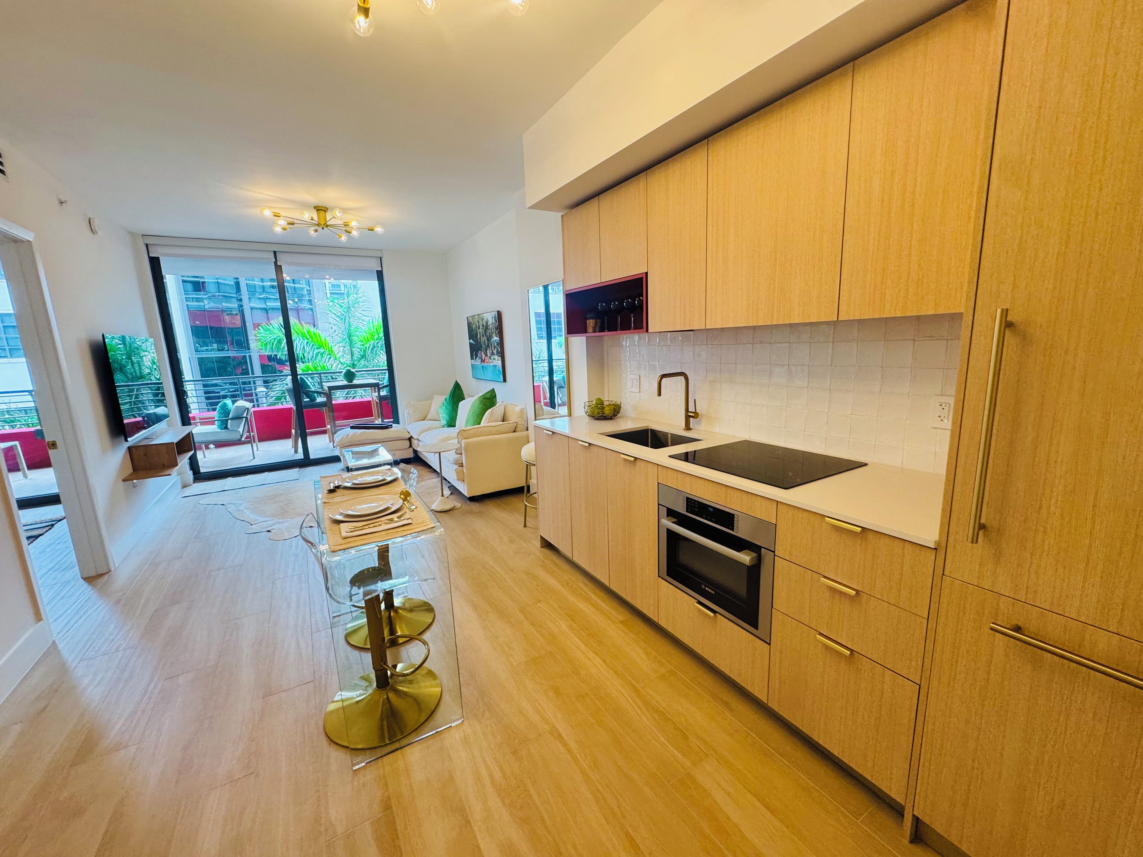 A modern kitchen with wooden cabinets, a stainless steel sink, and a built-in oven.