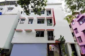 Un edificio de varios pisos con fachada plana, múltiples ventanas y entrada a nivel de calle.