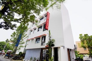 A multi-story building with a red sign indicating a guest house. - Hotel O ROYAL REGENCY (Kolkata)