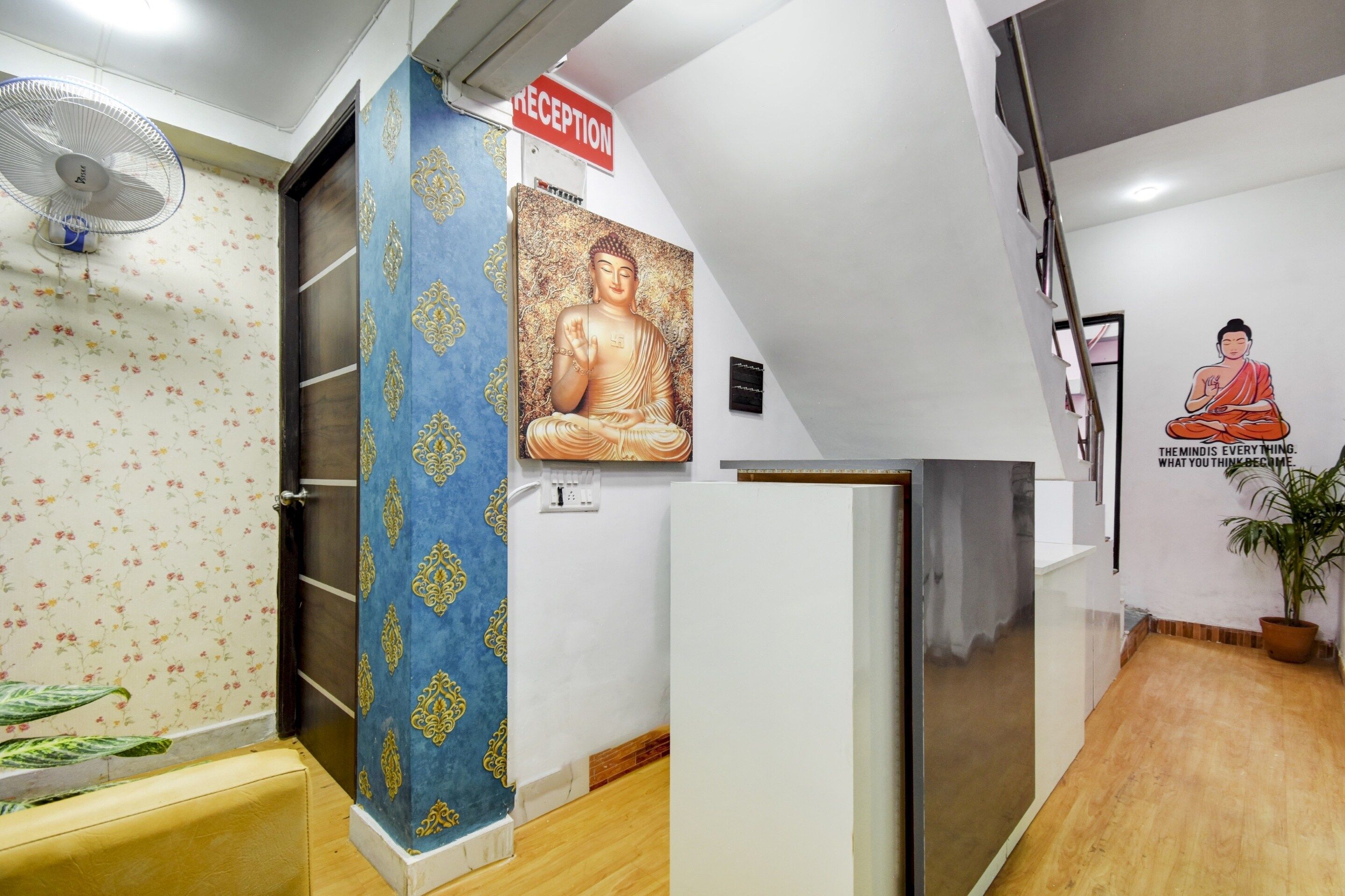 A reception area with a reception desk, a wall-mounted Buddha statue, and a motivational quote.