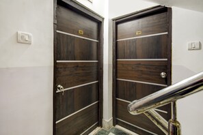 Two wooden doors with white horizontal stripes and a metal handrail in front. - Hotel O ROYAL REGENCY (Kolkata)