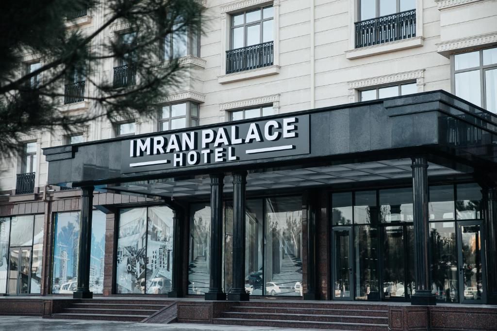 The exterior of the Imran Palace Hotel with a covered entrance and large windows reflecting the surroundings.