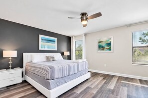 A bedroom with a bed, nightstands, a ceiling fan, and artwork on the walls. - 6BR house with spa / jacuzzi near Disney (Davenport)