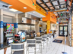 A restaurant with a counter, seating area, and a large kitchen. - 6BR with private pool and spa / jacuzzi (Davenport)