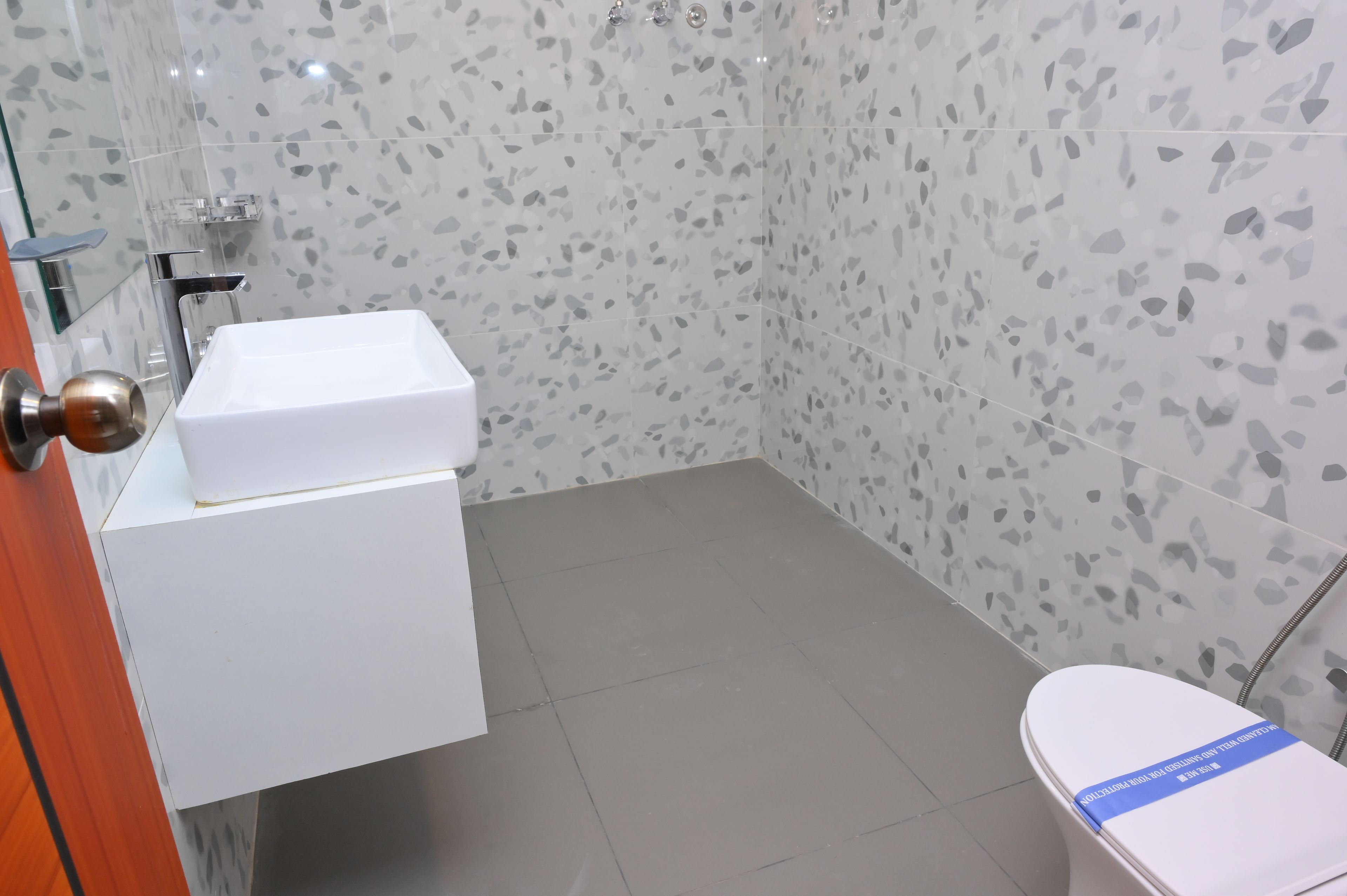 A bathroom with a white sink, a toilet, and a shower area.