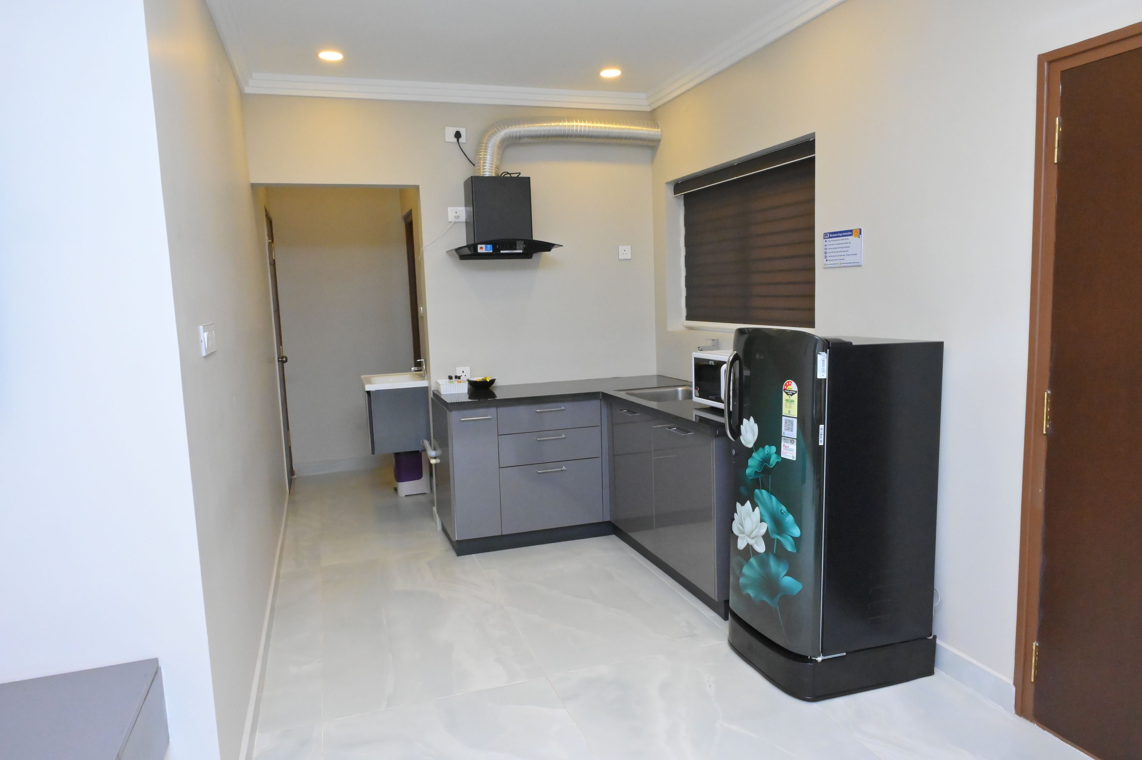 A compact kitchen with a refrigerator, microwave, and a small countertop.