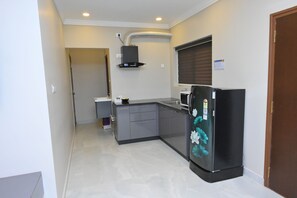Cocina compacta con refrigerador, microondas y una pequeña encimera.