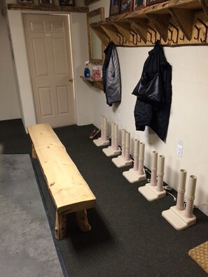 A room with a wooden bench, a wall-mounted coat rack, and a row of white cylindrical objects. - Sun Bird Townhome - pet friendly (Ketchum)