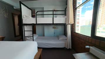 Habitación con literas, un escritorio y un radiador.
