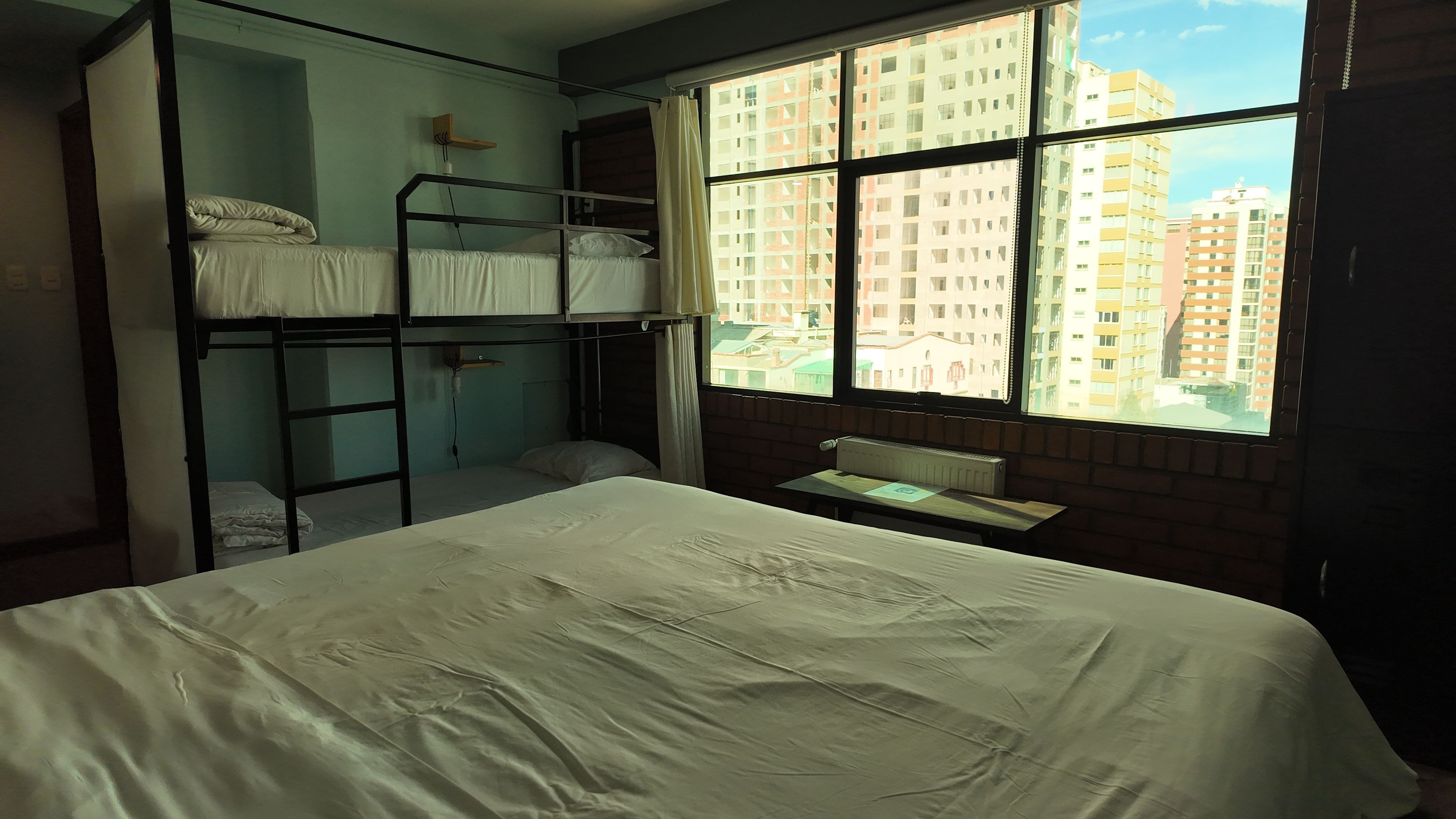 Dormitorio con literas y vista a edificios.