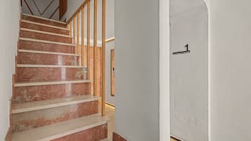 Een trap met houten leuningen die uitkomt op een plateau.