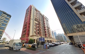 A multi-story parking structure with a clear entrance and a sign indicating payment. - Twin Bed Partition Room Near ICM Metro (Dubai)