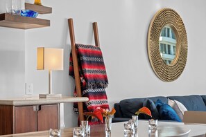 Een moderne woonkamer met een bank, een lamp, een spiegel en een houten ladder.