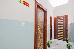 A hallway with a 'No Smoking' sign, a door with a number '301', and a potted plant. - Hotel O Diamond Regency (Kolkata)