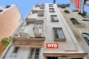 A building with multiple air conditioning units, a visible entrance, and a sign for 'OYO ROOMS'. - Hotel O Diamond Regency (Kolkata)