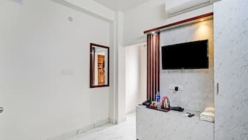 A hotel bathroom with a marble vanity, a mounted TV, and a towel rack.