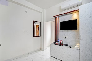 A hotel bathroom with a marble vanity, a mounted TV, and a towel rack. - Hotel O Diamond Regency (Kolkata)