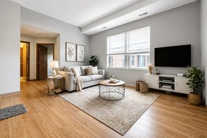 A modern living room with a sofa, coffee table, and TV. - Flash Offer Cozy 1-bedroom condo in adorable Minneapolis for 1859/Month (Minneapolis)