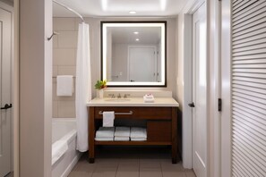 Un bagno moderno con vasca, una toeletta con specchio e zona doccia.