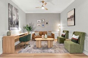 A modern living room with a desk, two sofas, a coffee table, and a ceiling fan. - Designer Luxury 3BR Stunning Lake View Vista Cay (Orlando)