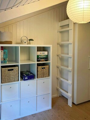 A white shelving unit with various items, including board games and baskets. - Nature plot with wild tub near Bratten Strand (Jerup)