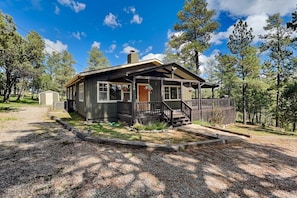 A cabin with a porch, a front door, and a chimney. - Gonzo Chalet (Ruidoso)