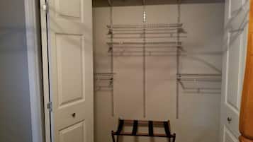 Un dressing avec des étagères en métal et un banc en bois.