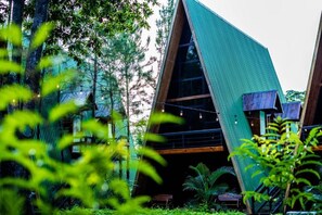 A modern building with a sloped roof, surrounded by lush greenery. - Hacienda Rubí Club & Resort (Moncagua)